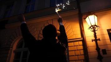 homme avec une torche du bengale en feu marchant heureux dans la rue de la ville de nuit célébrer video