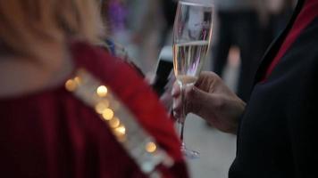 donna tiene in mano un bicchiere di vino bianco a una festa video