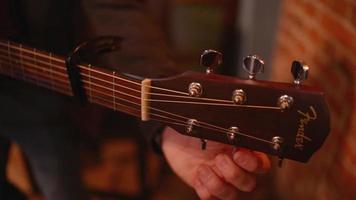 Close-up a man hand sets up a Guitar Strings to play in a Restaurant Evening video