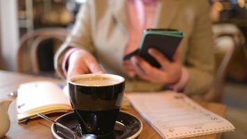 mujer de negocios en un almuerzo escribe un mensaje en el teléfono móvil en un restaurante video