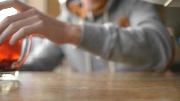 un hombre vierte miel en una taza de té con naranja, bayas video