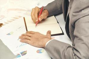 business man sitting writing text note and use red pen on work table at office photo