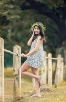 pretty women in grass crown and makeup posing gracefully on green outdoors photo