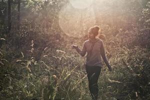 A young woman walking trekking through a green path in forest mountain summer sunrise thailand. photo
