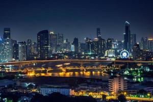 Bangkok thailand cityscape at night many tower near river photo