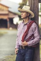 Handsome young man wearing cowboy hat standing thinking photo