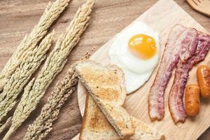 breakfast setting with black coffee and sauaage bacon omelette on the table wooden photo