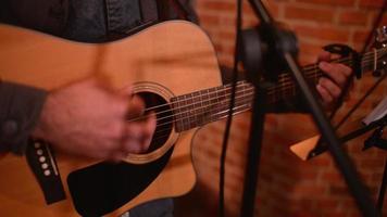 primer plano, una mano de hombre configura cuerdas de guitarra para tocar en una noche de restaurante video