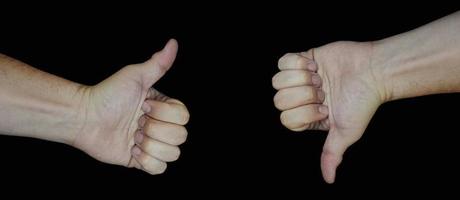 Hand gesture with thumbs up and down isolated on black background photo