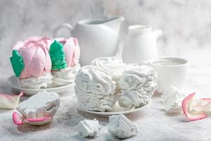 Handmade marshmallows on a light background in the form of roses, hydrangeas and tulips. There are flowers nearby. Women's day, Valentine's day. photo