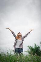 Young beautiful hipster woman in a flower field at sunset. Freedom enjoying with nature. photo