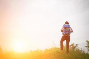 joven hipster al aire libre con mochila en el hombro, hora de viajar, aventura con caminatas. foto