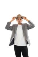 Portrait of young hipster man adjusting hat with head at camera on isolated over white studio background. photo