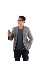 Young hipster man holding his smart phone standing isolated on white background. photo