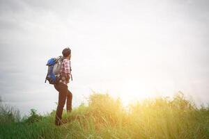 joven hipster al aire libre con mochila en el hombro, hora de viajar, aventura con caminatas. foto