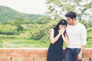 Young handsome boyfriend hugging his girlfriend, she was sad and upset. photo