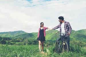 joven hipster pareja cogidos de la mano caminando por el prado ambiente relajante y natural es muy natural. foto