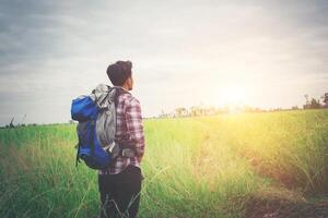 hombre hipster con una mochila sobre los hombros, hora de viajar, concepto de turismo. foto