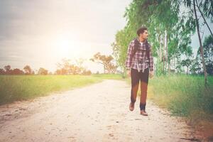 Young happy hipster traveler walking overcome big way smiling looking away, adventure travel and discovery. photo