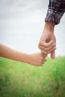 primer plano del padre sosteniendo la mano de su hija, tan dulce, tiempo en familia. foto