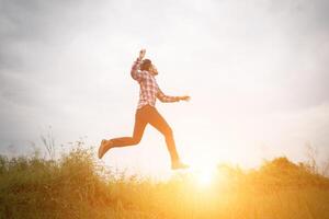 hombre hipster salta alto, libertad disfrutando con la naturaleza alrededor. foto