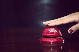 woman's hands press sex bell on a reception bell. concept about sex and eroticism photo