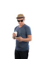 Young hipster man looking at his smart phone and coffee in hands isolated on white background. photo