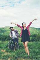 Young hipster couple holding hands walking on the meadow relaxing and natural atmosphere is very natural. photo