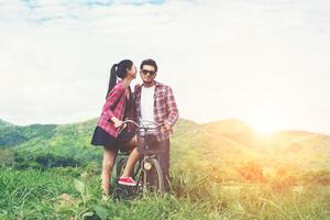 joven hipster pareja cogidos de la mano caminando por el prado ambiente relajante y natural es muy natural. foto