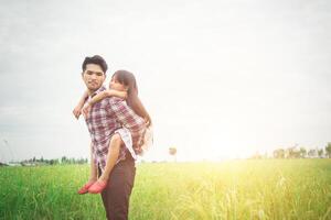 feliz padre y niña jugando en el campo de los prados, disfrutando juntos. foto