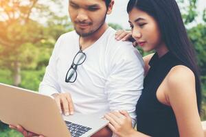 Young education couple talking about education after reading book with laptop ,Relaxing with nature. photo