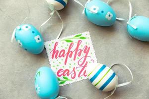 Happy Easter concept. Preparation for holiday. Blue Easter eggs Inscription HAPPY EASTER letters text on concrete stone grey background. Flat lay top view copy space. photo