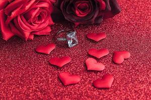 Will you marry me. Wedding ring red scarlet roses and many red hearts on red glitter background. Engagement marriage proposal wedding concept. St. Valentine's Day postcard. Banner on valentines day. photo