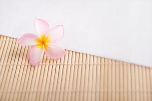 flor de plumeria sobre fondo blanco y madera. foto