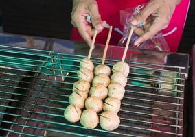 grill meatball on steel grating, a street food market photo