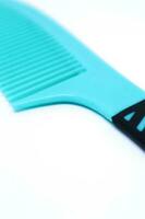 Detail of An Aqua Blue Comb in The White Background with Oblique Top Shot, Portrait Mode and Minimalist photo