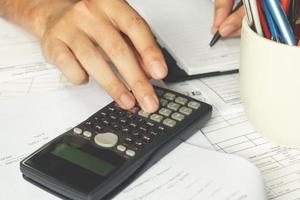 Businessman using a calculator to calculate the numbers. Accounting, soft focus. photo