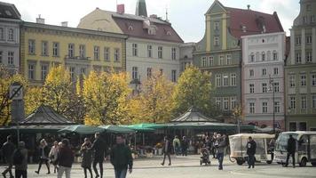 praça do mercado no centro da cidade de wroclaw - muitas pessoas turistas em dia ensolarado video