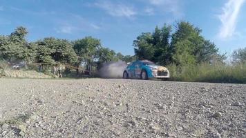 les gens regardent un spectacle de course automobile avec des nuages de poussière qui montent - prenant une vidéo par téléphone video