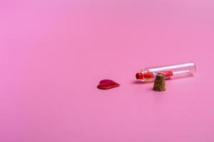 Message in a bottle on a pink background with a heart. Holiday concept. Closeup with copy space photo