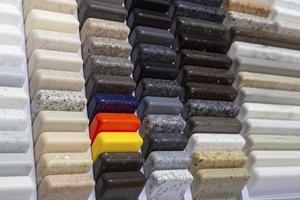 Samples of natural granite, marble, quartz stone, countertops and a sample of natural parquet. Model made of stones, closeup. Modern colored slabs made of natural stone. photo