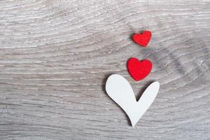 Three hearts on a wooden background. Concept for valentine's day, mother's day or parental care concept for a child. copy space photo