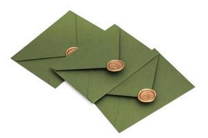 green envelope with designer cardboard and seal on a white background. Envelope with seal photo