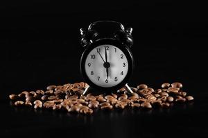 time to wake up. lack old style alarm clock isolated on black. clock with coffee beans on a dark background photo