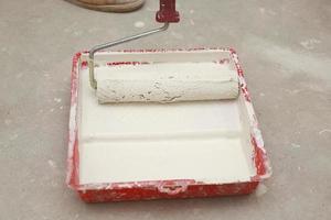 Cropped-image of a builder using paint roller in his work indoors photo