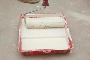 Cropped-image of a builder using paint roller in his work indoors photo