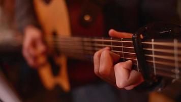 close-up een mannenhand zet een gitaarsnaren op om te spelen in een restaurantavond video