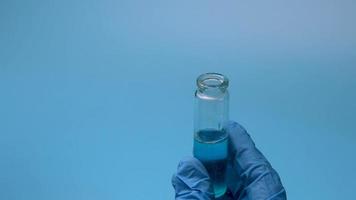 Transfusion of blue liquid from a test tube into flasks. video