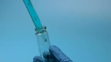 transfusion de liquide bleu d'un tube à essai dans des flacons. video