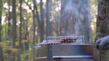 gire la rejilla con la carne en la parrilla. el concepto de deliciosa comida y recreación al aire libre. video
